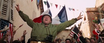 Movie still from “Kelly's Heroes” (1970), directed by Brian G. Hutton – A man in a green jacket is holding his arms up; Medium shot, Low angle