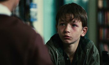 Movie still from “Kes” (1969), directed by Ken Loach – A young boy looking at the camera in front of a mirror; Close Up shot, Over the shoulder angle