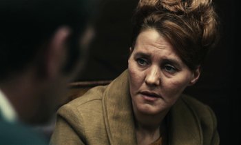 Movie still from “Kes” (1969), directed by Ken Loach – An older woman is sitting in front of a man; Close Up shot, Over the shoulder angle