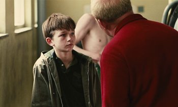 Movie still from “Kes” (1969), directed by Ken Loach – A young boy and an older man in front of a bathroom mirror; Close Up shot, Over the shoulder angle