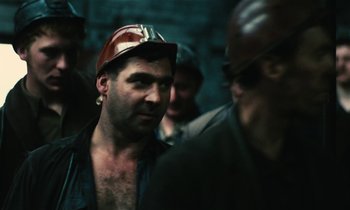 Movie still from “Kes” (1969), directed by Ken Loach – A group of men standing next to each other; Close Up shot, High angle