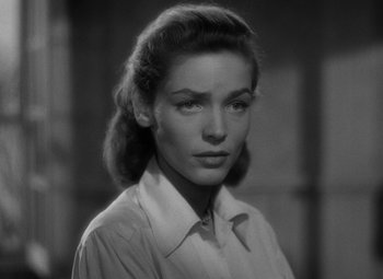 Movie still from “Key Largo” (1948), directed by John Huston – A black and white photo of a woman in a dress shirt; Close Up shot, Low angle