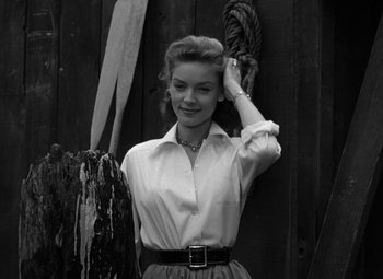 Movie still from “Key Largo” (1948), directed by John Huston – A black - and - white photo of a woman holding her hair up; Medium shot, Low angle