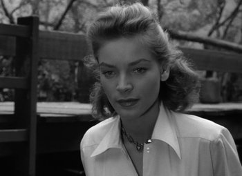 Movie still from “Key Largo” (1948), directed by John Huston – A black - and - white photo of a woman in a white shirt; Close Up shot, Low angle