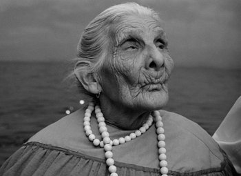 Movie still from “Key Largo” (1948), directed by John Huston – An old woman with a long white necklace looks into the distance; Close Up shot, Low angle
