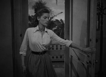 Movie still from “Key Largo” (1948), directed by John Huston – A black - and - white photo of a woman opening a door; Medium shot, Low angle