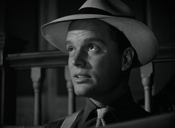 Movie still from “Key Largo” (1948), directed by John Huston – A black and white photo of a man wearing a hat; Close Up shot, Low angle