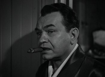 Movie still from “Key Largo” (1948), directed by John Huston – A man with a cigar in his mouth; Close Up shot, Low angle