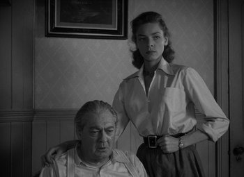 Movie still from “Key Largo” (1948), directed by John Huston – An older man sitting next to an older woman; Medium shot, Low angle