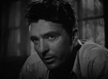 Movie still from “Key Largo” (1948), directed by John Huston – Black and white photograph of a man with a serious look; Close Up shot, Low angle