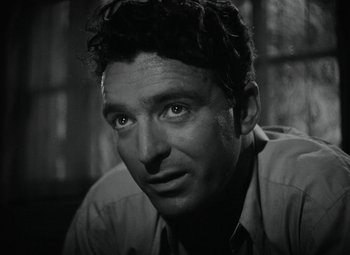 Movie still from “Key Largo” (1948), directed by John Huston – Black and white photograph of a man with a serious look; Close Up shot, Low angle