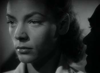 Movie still from “Key Largo” (1948), directed by John Huston – A black - and - white photo of a woman's face; Close Up shot, Over the shoulder angle