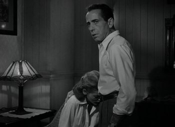 Movie still from “Key Largo” (1948), directed by John Huston – A black and white photo of a man and a woman; Medium shot, Low angle