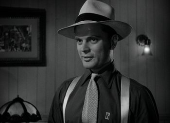 Movie still from “Key Largo” (1948), directed by John Huston – A black and white photo of a man wearing a hat and a tie; Close Up shot, Low angle