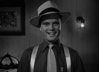 Movie still from “Key Largo” (1948), directed by John Huston – A man wearing a hat and suspenders and a tie; Close Up shot, Low angle