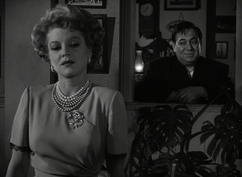 Movie still from “Key Largo” (1948), directed by John Huston – An old photo of a woman and a man; Medium shot, Over the shoulder angle