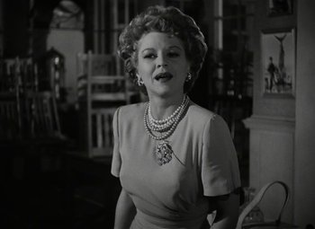 Movie still from “Key Largo” (1948), directed by John Huston – An old photo of a woman in a dress; Medium shot, Low angle