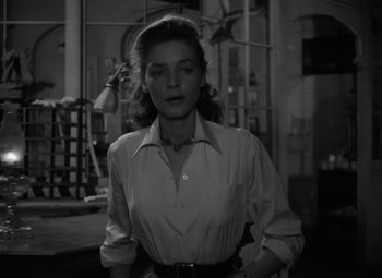 Movie still from “Key Largo” (1948), directed by John Huston – A black - and - white photo of a woman in a white shirt; Medium shot, Low angle