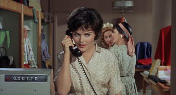 Movie still from “Kid Galahad” (1962), directed by Phil Karlson – A woman talking on a phone while two other women look on; Close Up shot, High angle
