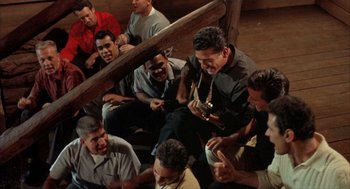 Movie still from “Kid Galahad” (1962), directed by Phil Karlson – A group of men sitting on the ground; Medium shot, High angle