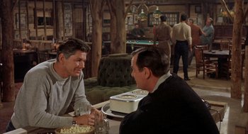 Movie still from “Kid Galahad” (1962), directed by Phil Karlson – Two men sitting at a table in a restaurant; Medium shot, Over the shoulder angle