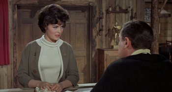 Movie still from “Kid Galahad” (1962), directed by Phil Karlson – A woman sitting at a table talking to a man; Medium shot, Over the shoulder angle