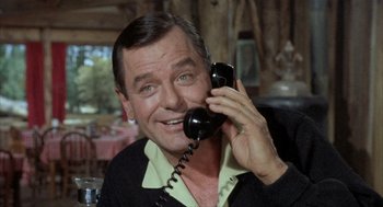 Movie still from “Kid Galahad” (1962), directed by Phil Karlson – An older man talking on a phone while wearing a sweater; Close Up shot, Low angle