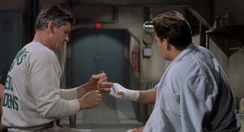 Movie still from “Kid Galahad” (1962), directed by Phil Karlson – Two men in a hospital room with bandages on their hands; Medium shot, Low angle
