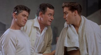 Movie still from “Kid Galahad” (1962), directed by Phil Karlson – A group of men standing next to each other in a room; Medium shot, Low angle