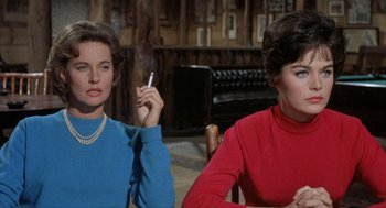 Movie still from “Kid Galahad” (1962), directed by Phil Karlson – Two women sitting at a table with a cigarette in their mouth; Medium shot, Low angle