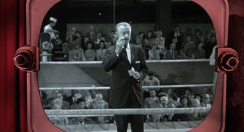 Movie still from “Kid Galahad” (1962), directed by Phil Karlson – An old photo of a man in a boxing ring talking on a phone; Medium shot, High angle