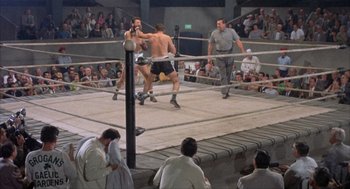 Movie still from “Kid Galahad” (1962), directed by Phil Karlson – A boxing match in progress in an old boxing ring; Wide shot, High angle