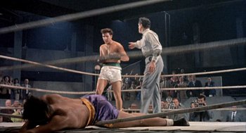 Movie still from “Kid Galahad” (1962), directed by Phil Karlson – Two men in a boxing ring with a crowd in the background; Wide shot, Low angle