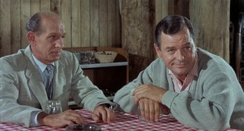 Movie still from “Kid Galahad” (1962), directed by Phil Karlson – Two men sitting at a table in front of a checkered tablecloth; Medium shot, Over the shoulder angle