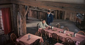 Movie still from “Kid Galahad” (1962), directed by Phil Karlson – Two men are sitting at a table in a restaurant; Wide shot, High angle
