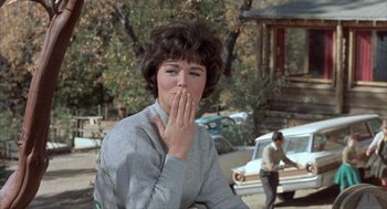 Movie still from “Kid Galahad” (1962), directed by Phil Karlson – A woman covers her mouth with her hand; Close Up shot, Over the shoulder angle