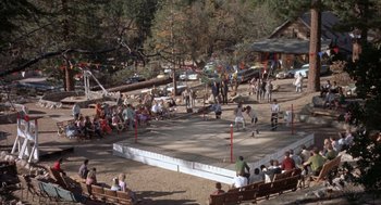 Movie still from “Kid Galahad” (1962), directed by Phil Karlson – A group of people sitting on a bench in a park; Extreme Wide shot, High angle