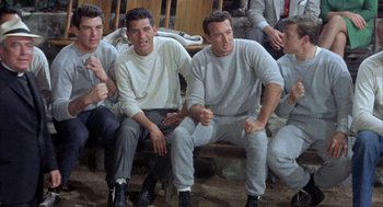 Movie still from “Kid Galahad” (1962), directed by Phil Karlson – A group of young men sitting on a bench; Medium shot, High angle