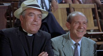 Movie still from “Kid Galahad” (1962), directed by Phil Karlson – Two men sitting next to each other wearing hats; Medium shot, Low angle