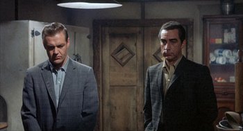 Movie still from “Kid Galahad” (1962), directed by Phil Karlson – Two men standing next to each other in front of a wooden door; Medium shot, Low angle