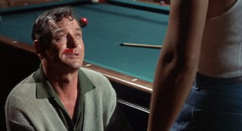 Movie still from “Kid Galahad” (1962), directed by Phil Karlson – A man sitting in front of a pool table; Close Up shot, Over the shoulder angle