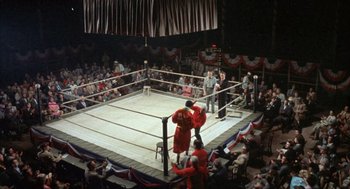Movie still from “Kid Galahad” (1962), directed by Phil Karlson – A boxing match in a boxing ring with spectators watching it; Extreme Wide shot, High angle