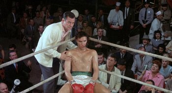 Movie still from “Kid Galahad” (1962), directed by Phil Karlson – A man in a boxing ring with a trainer; Medium shot, Low angle