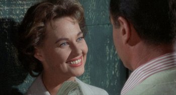 Movie still from “Kid Galahad” (1962), directed by Phil Karlson – A woman smiles at a man in a suit; Close Up shot, Over the shoulder angle