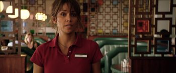 Movie still from “Kidnap” (2017), directed by Luis Prieto – A woman in a red shirt is standing in front of a table; Close Up shot, Over the shoulder angle