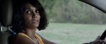 Movie still from “Kidnap” (2017), directed by Luis Prieto – A person wearing a yellow shirt near a field; Close Up shot, Over the shoulder angle