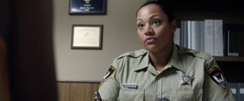 Movie still from “Kidnap” (2017), directed by Luis Prieto – A female police officer is sitting in a room; Close Up shot, Over the shoulder angle