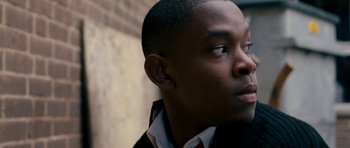Movie still from “Kidulthood” (2006), directed by Menhaj Huda – A person wearing a suit and tie; Close Up shot, Low angle
