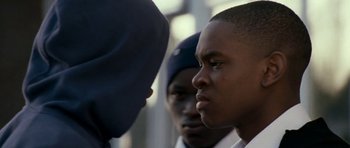 Movie still from “Kidulthood” (2006), directed by Menhaj Huda – A group of young men standing next to each other on a street; Close Up shot, Over the shoulder angle