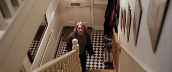 Movie still from “Kidulthood” (2006), directed by Menhaj Huda – A woman standing on the stairs of a house; Wide shot, High angle